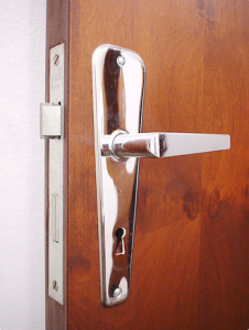 En tredør med dørhåndtak og lås i sølv