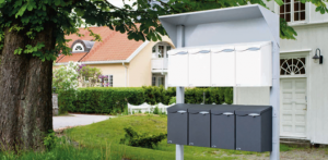 Et postkassestativ med hvite og sorte postkasser utenfor et boligfelt